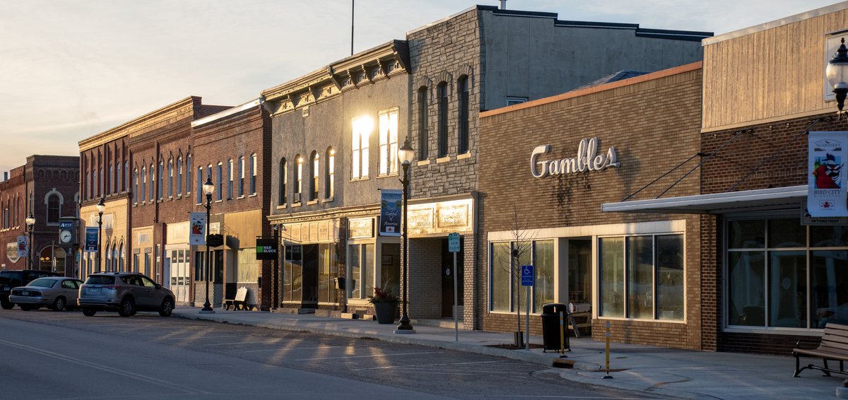 Main street storefronts in a small Midwest town at sunset