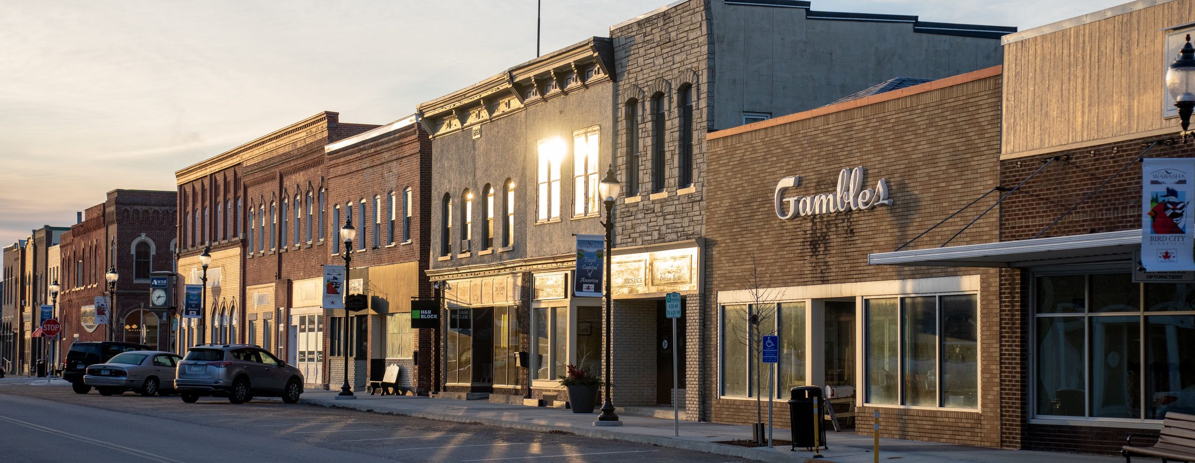 Main street storefronts in a small Midwest town at sunset